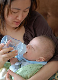 Mother bottle feeding child