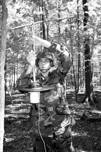 Army Spc. Clark Dutterer, a preventive medicine specialist at the U.S. Army Center for Health Promotion and Preventive Medicine at Aberdeen Proving Ground, Maryland, sets a light trap to catch adult mosquitoes in the Maryland woods. The mosquitoes are then tested to see if they are carrying certain diseases. The trap was supplied by the Centers for Disease Control and Prevention.