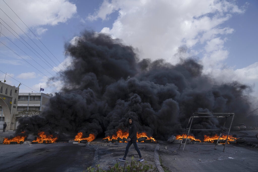 Palestinian protesters block the main road with burning tires in the West Bank city of Jericho, Monday, Feb. 6, 2023. Israeli forces killed five Palestinian gunmen in a raid on refugee camp in the occupied West Bank on Monday, the latest bloodshed in the region that will likely further exacerbate tensions