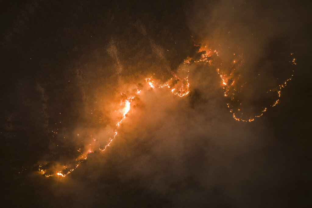 Trees burn as flames and smoke engulf an area in Santa Juana, Chile, Monday, Feb. 6, 2023. 