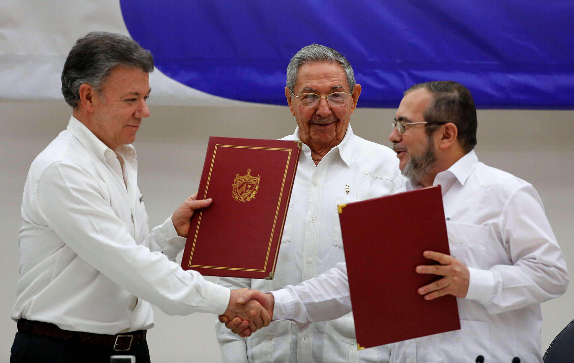 Farc leader and Columbian president shaking hands.
