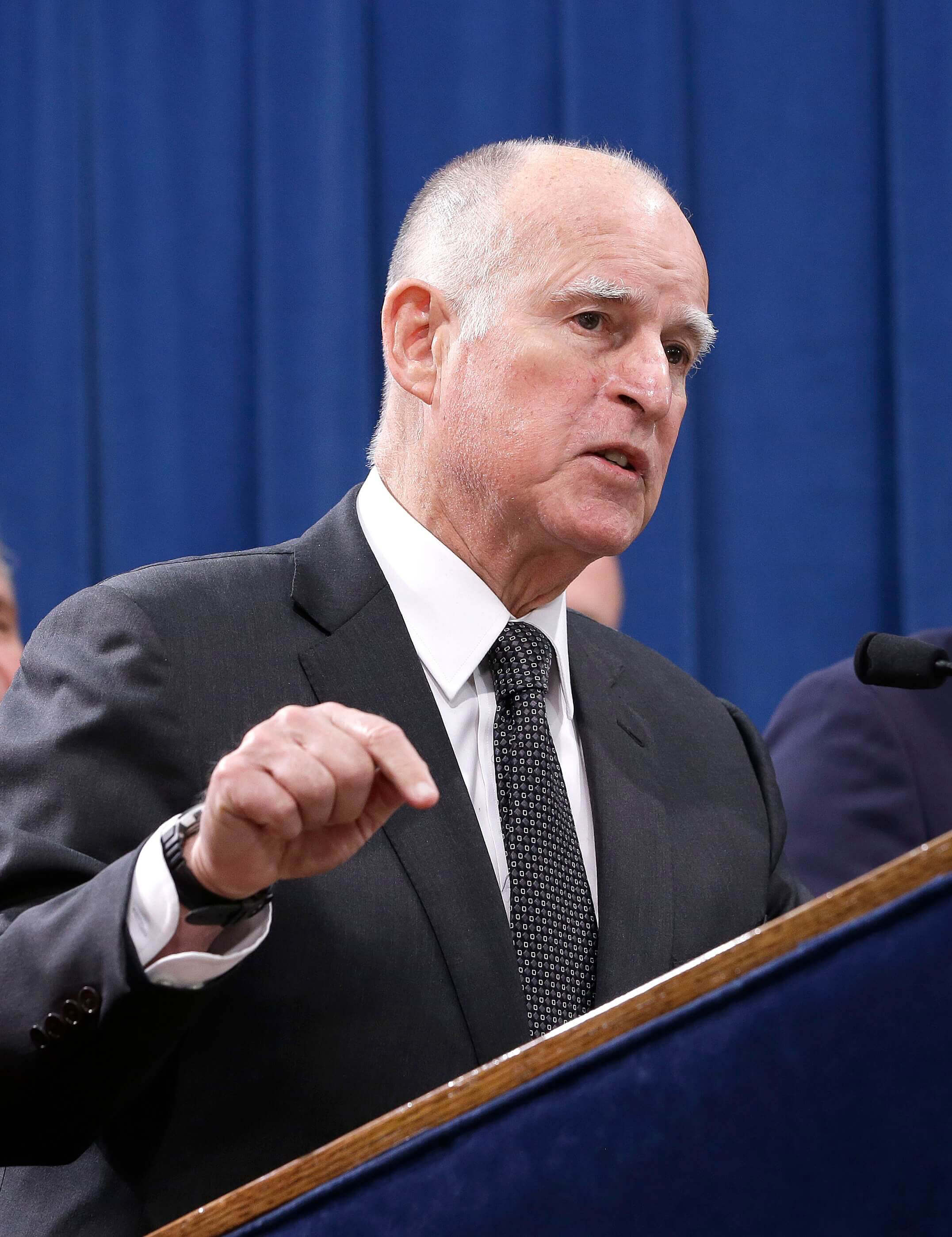 jerry brown at a news conference announcing $15 minimum wage