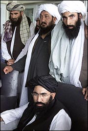 Afghan Ambassador to Pakistan Abdul Salam Zaeef seated in front of Taliban militia members. Source/AP Photos