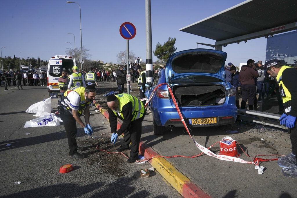 Members of Zaka Rescue and Recovery team work at the site of a car-ramming attack at a bus stop in Ramot, a Jewish settlement in east Jerusalem, Friday, Feb. 10, 2023.