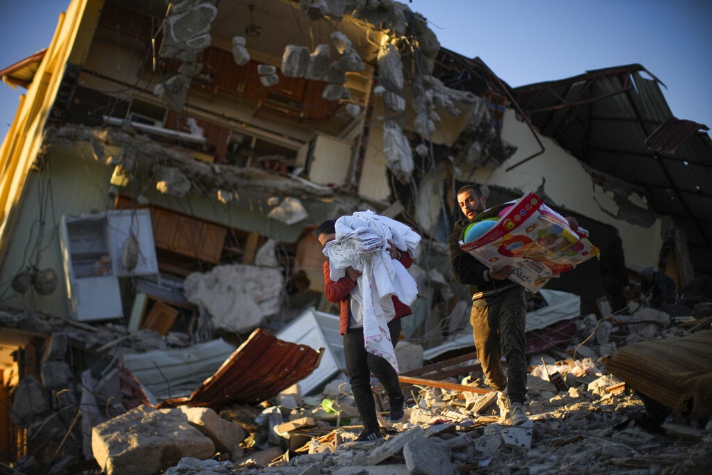 Residentes remove their belongings from their destroyed house after the earthquake, in Samandag, southern Turkey, Thursday, Feb. 16, 2023