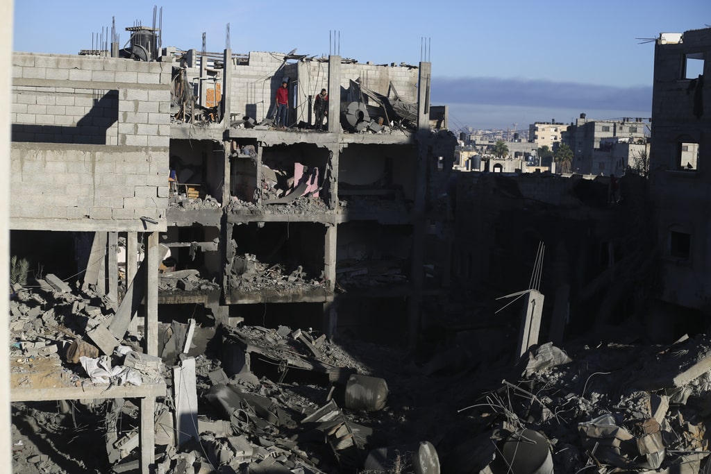 Palestinians look at the destruction after an Israeli strike on residential buildings in Rafah, Gaza Strip, on Friday, Dec. 15, 2023.
