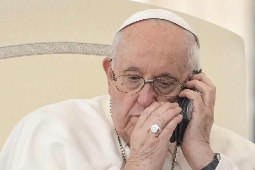 Pope Francis talks on the phone during his weekly general audience in St. Peter's Square at the Vatican, Wednesday, May 17, 2023