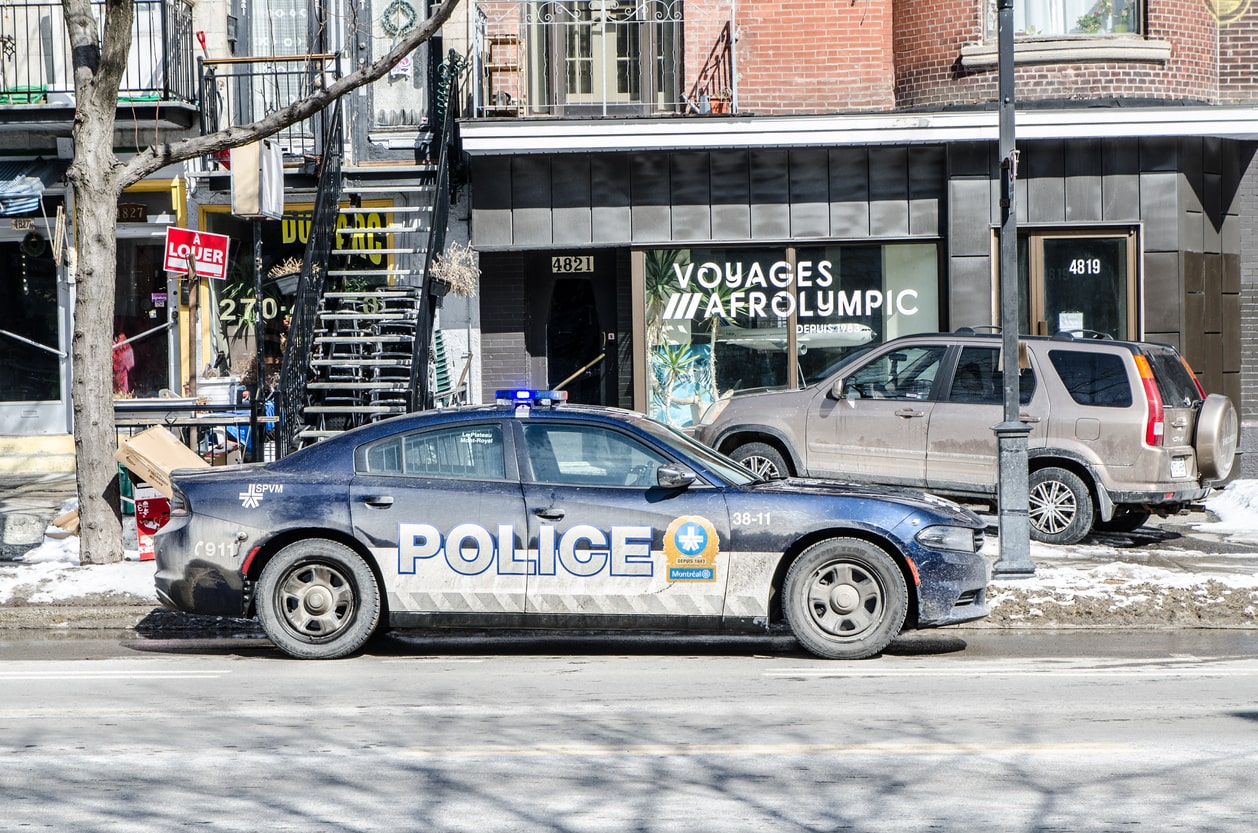 One police car in front of store on St-Denis Street in Montreal during day of winter