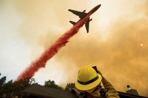 A plane drops fire retardant to combat wildfires. 