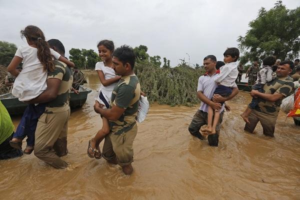 Indian soldiers carry children from the flooded regions. 